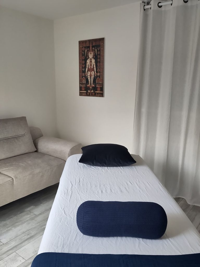 Vue de la salle de soin à Clamart avec un table de massage et deux coussins